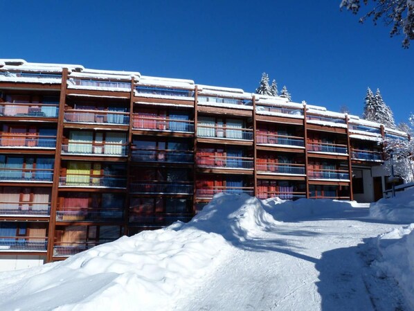 A multi-story hotel with balconies, surrounded by snow.