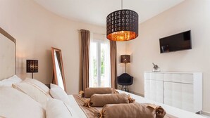 A modern bedroom with a large bed, a TV, and a ceiling light fixture. - Luxury  Villa   Adrian (Vela Luka)