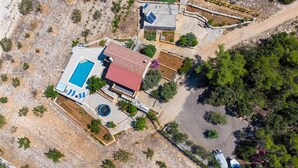 An aerial view of a property with a swimming pool, a red-roofed building, and surrounding vegetation. - Holiday House  Gabrijel (Cara)