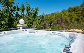 A hot tub with water jets, surrounded by lush greenery and a clear sky. - Holiday House  Gabrijel (Cara)