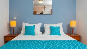 A hotel room with a bed, two nightstands, two lamps, a mirror, and a blue polka dot bedspread. - House House Čafo- Padovan (Vela Luka)