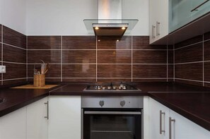 Kjøleskap, ovn, kjøkkenutstyr og spisebord