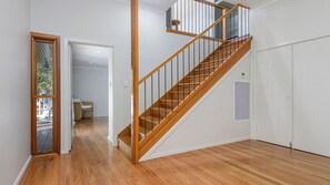 A staircase with wooden steps and metal railings, leading to an upper floor.