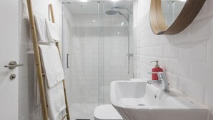 Un baño con ducha, lavabo e inodoro.