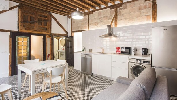 Una cocina compacta con comedor, lavadora y refrigerador.