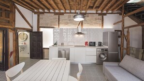 Una cocina compacta con una isla central, lavadora y refrigerador.