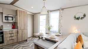Una cocina moderna con microondas, armarios de madera y un piso con patrón de espiga.