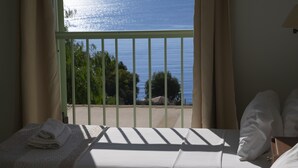 A room with a bed, a view of the sea, and a balcony with a railing. - Kerasia Bay View Villa (Corfu)