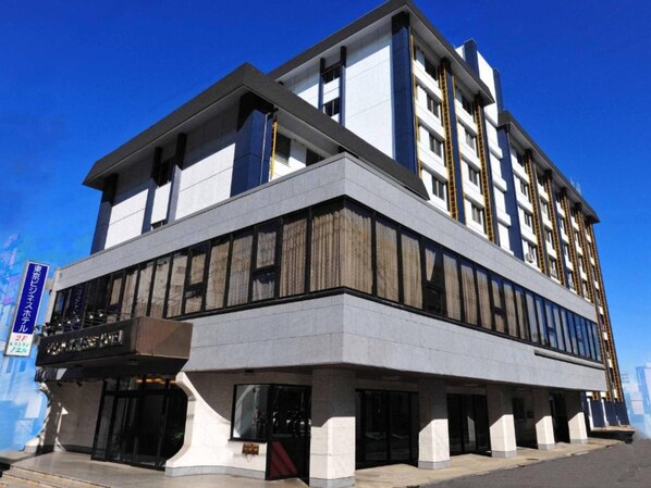 Stunning hotel building with a corner entrance, featuring large windows and balconies on multiple levels.