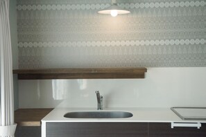 Una cocina moderna con un lavamanos blanco, encimera de madera y un salpicadero decorativo.
