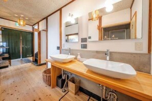Un baño moderno con dos lavamanos grandes, encimeras de madera y un espejo encima.