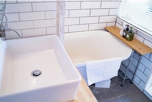 Bathroom features a white bathtub, sink, and tiled floor.