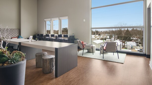 A modern office space with a large desk, comfortable seating, and large windows offering a view of the outside. -     Sip, Stay & Explore Traverse City Wine Country. Near all TC has to offer! (Traverse City)