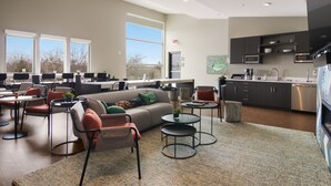 A spacious living area with a sofa, chairs, and tables. There is a kitchen with modern appliances and cabinets. -     Sip, Stay & Explore Traverse City Wine Country. Near all TC has to offer! (Traverse City)