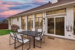 A house with a covered patio, a dining area, and a large sliding glass door.