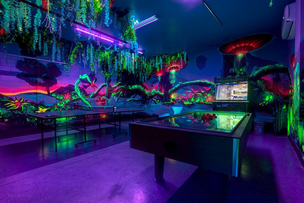A room with a pool table, hanging plants, and a large mushroom decoration.