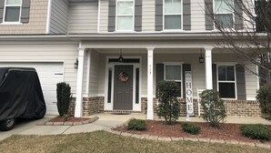 A two-story house with a covered garage, a front porch with a welcome sign, and a mailbox. - Beautiful  5 bdrm, 3 bthrm, 15 minutes to the Masters (Grovetown)