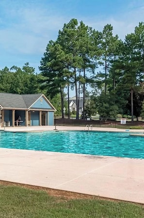 A swimming pool with a small building in the background.
