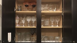 A kitchen with a dark cabinet containing various glassware and a tiled backsplash. - Beautiful  5 bdrm, 3 bthrm, 15 minutes to the Masters (Grovetown)