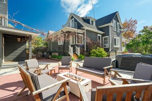 Een terras met tuinmeubilair en een vuurkorf.