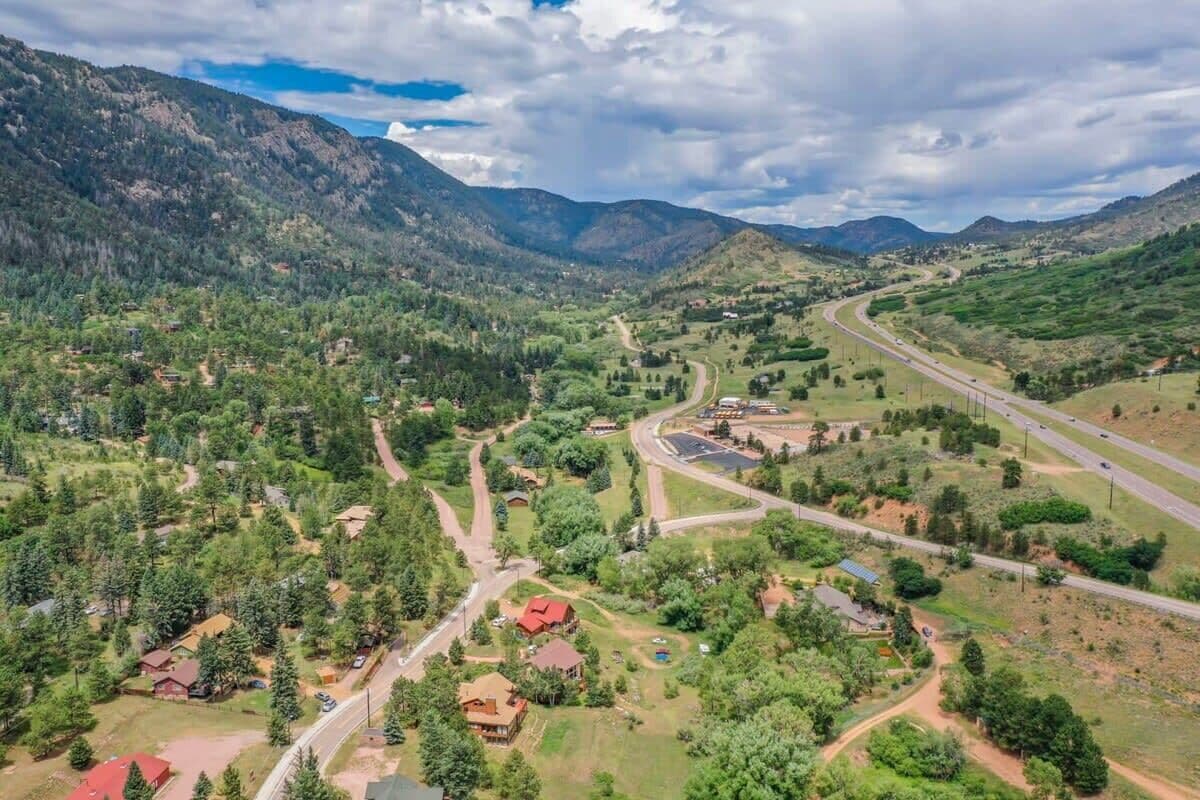 A mountainous landscape with a winding road, residential areas, and a highway.