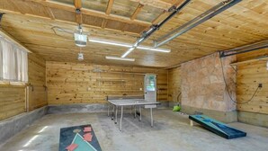 A room with a ping pong table, a stone wall, and a bench. - 4BR Mountain Getaway w/Hot Tub Firepit & Game Room (Cascade-Chipita Park)