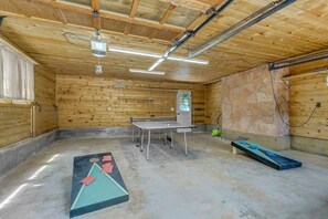 Een kamer met houten wanden, een tafeltennistafel, een stenen muur, en een tafeltennistafel met bats.
