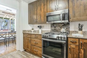 A modern kitchen with wooden cabinets, a stainless steel stove, and a microwave. - 4BR Mountain Getaway w/Hot Tub Firepit & Game Room (Cascade)