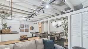 Un intérieur moderne avec un canapé, une table de billard et une table de ping-pong.