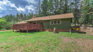 A single-story house with a green exterior, a covered porch, and a chimney. - 4BR Mountain Getaway w/Hot Tub Firepit & Game Room (Cascade-Chipita Park)