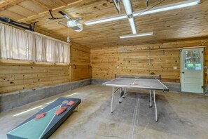 A ping pong table in a room with wooden walls and a ceiling fan.