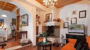 Un accogliente soggiorno con camino, televisore e zona pranzo con tavolo e sedie.