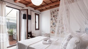 Una camera da letto con un letto, una finestra, una pianta in vaso e un balcone.