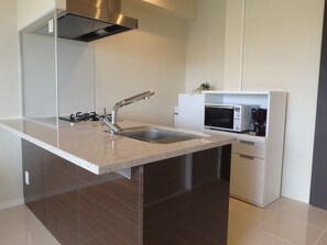A modern kitchen with a stainless steel sink, a microwave, and a built-in oven.