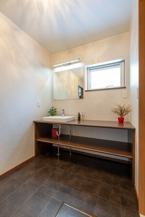 Une salle de bain moderne avec un grand miroir, un lavabo et une fenêtre.