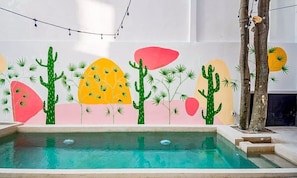 A pool area with a mural of cacti and desert plants on the wall. - Playa del Carmen Escape - Pool and Rooftop (Playa del Carmen)