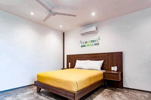 A bedroom with a wooden bed, a nightstand, an air conditioning unit, and a ceiling fan. - Playa del Carmen Escape - Pool and Rooftop (Playa del Carmen)
