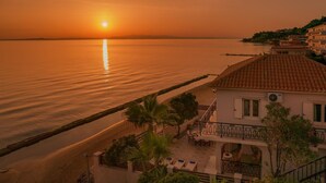 A coastal property with a balcony overlooking the sea, a sandy beach, and a building with a tiled roof. - Villa Elizabeth   Seafront Classic Villa! (Zakynthos)