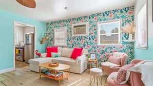 Ein Wohnzimmer mit einer Couch, Sesseln, einem Couchtisch und einem Bücherregal.