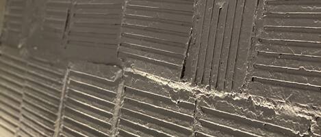 A close-up of a textured wall with a brick pattern.