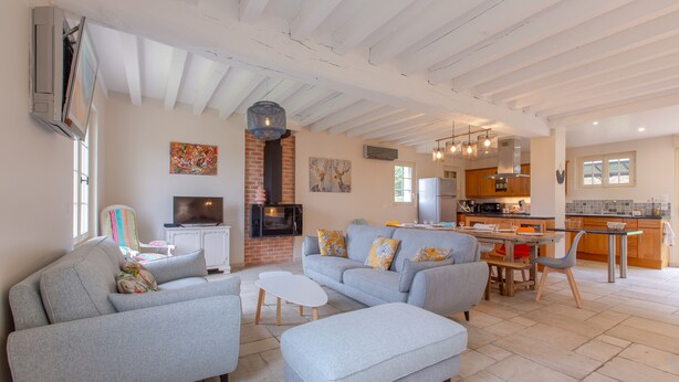 A spacious living room with a grey sofa set, a flat-screen TV, and a fireplace. - House (Chémery)