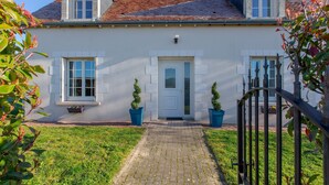 A white building with a tiled roof, a central door, and two windows on either side. - House (Chémery)
