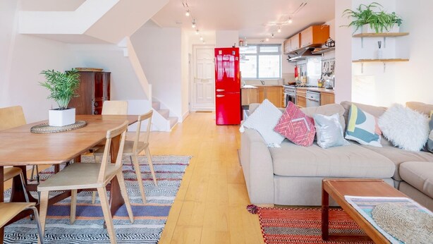 A modern living room with a dining area, a kitchen, and a staircase. - 3-Bedroom Duplex w/ Private Patio in Shoreditch - Pass the Keys (London)