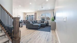 A spacious living room with a sectional sofa, a staircase, and a ceiling fan. - O-50&51 | 2 Homes! Pvt Heated Pool &  Pvt Hot Tubs (Santa Clara)