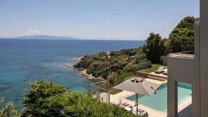 Ein Pool mit Meerblick, eine Treppe und ein Gebäude mit Balkon.