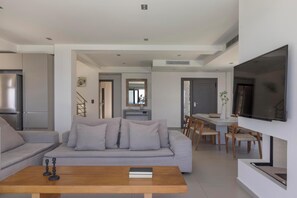 A modern living room with a sofa, coffee table, and a TV.