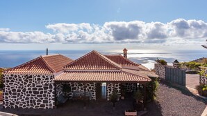 A coastal house with a tiled roof, stone walls, and a view of the sea. - Panoramic views and ideal area to rest and see the island of La Palma (Villa de Mazo)