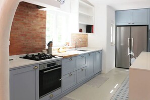 Enjoy cooking in this well-equipped kitchen with a gas stove, stainless steel appliances, and ample counter space.