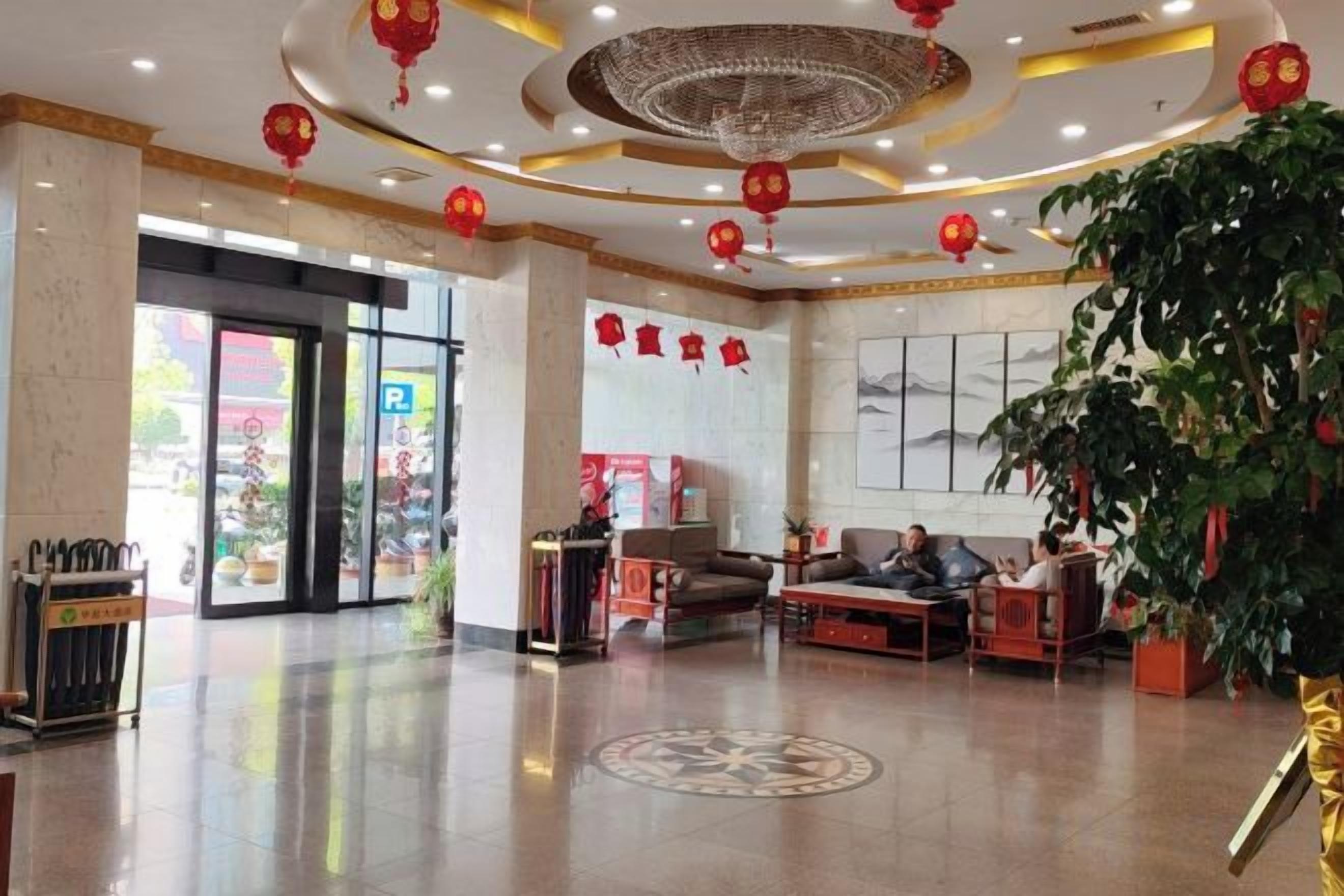 A lobby with a reception desk, seating area, and a large plant.