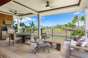 An outdoor patio area with a dining table, chairs, and a sofa.